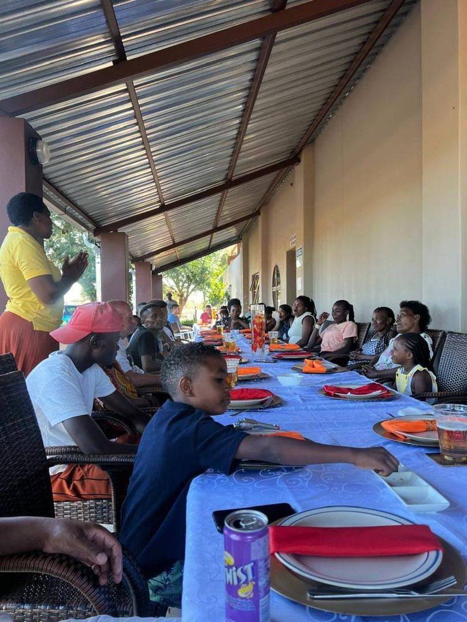 A long table set for a function at Omateko Lodge, guests seated under the patio